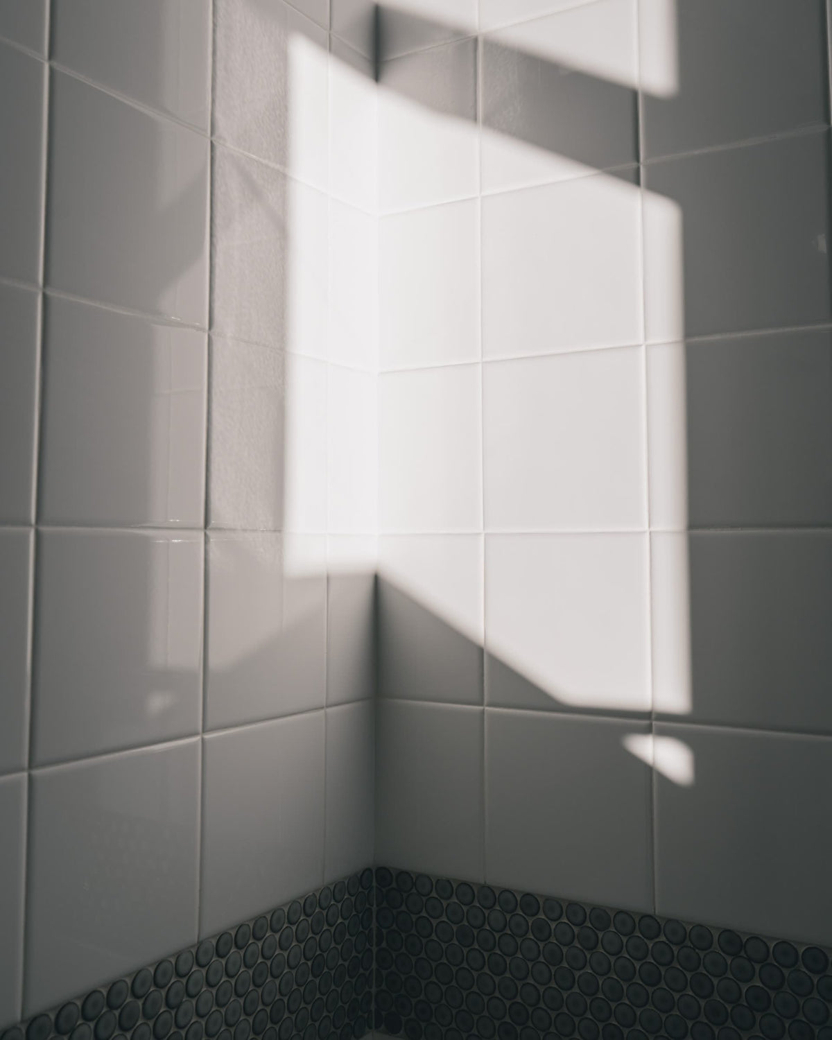 Azulejos de baño limpios con suaves dibujos de luz que entra por la ventana